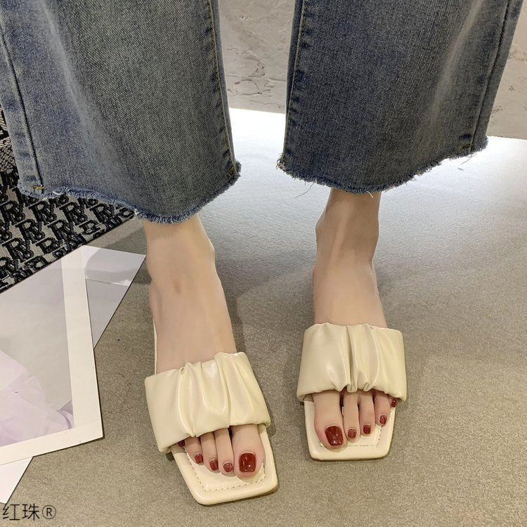 Sandales plates en cuir verni plié