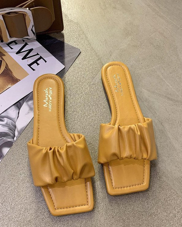 Sandales plates en cuir verni plié
